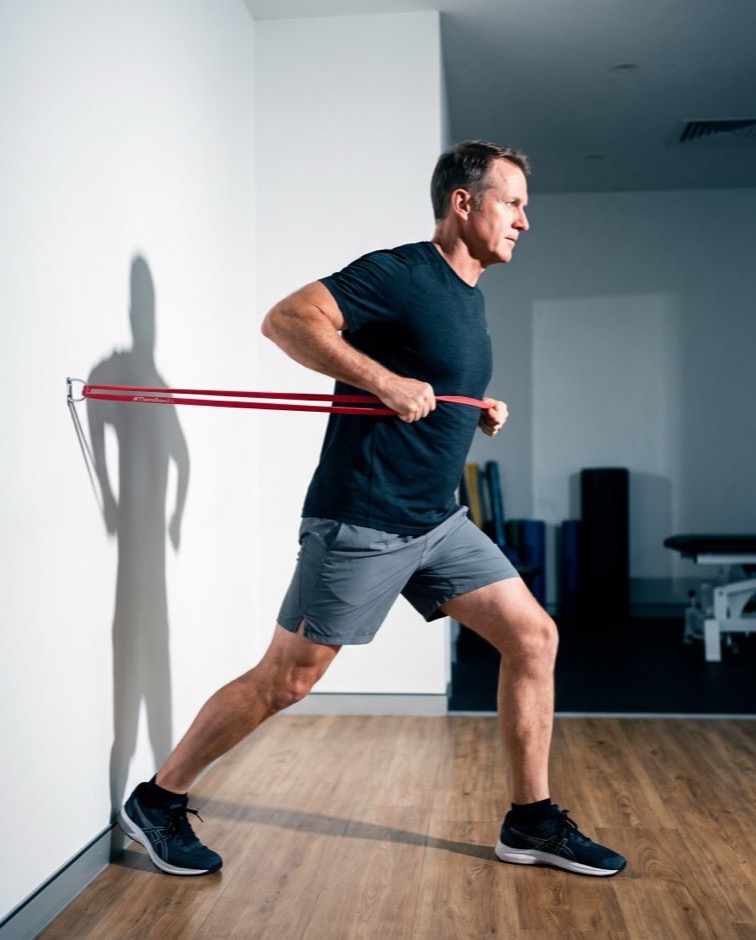 A man performing a resistance band row exercise